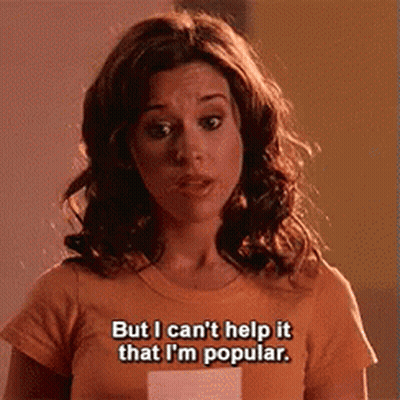 A Woman Wearing An Orange T-Shirt Says But I Can 'T Help It That I 'M Popular GIF