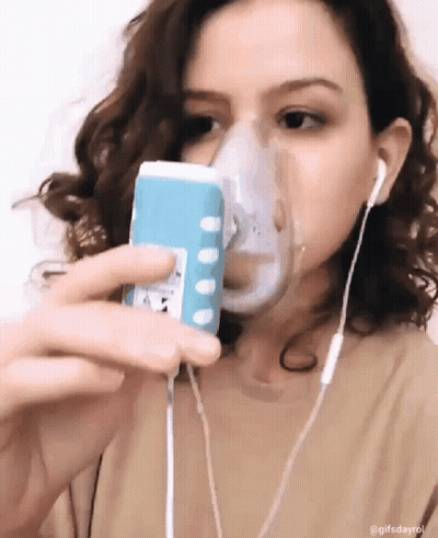 A Woman Wearing An Oxygen Mask Is Taking A Selfie With Her Phone GIF