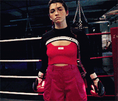 A Woman Wearing Boxing Gloves And A Crop Top That Says Bcci GIF