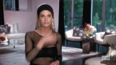 A Woman Wearing Chanel Earrings And A Black Headband GIF