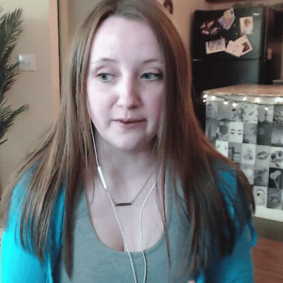 A Woman Wearing Ear Buds And A Necklace With A Pendant That Says ' I Love You ' On It GIF
