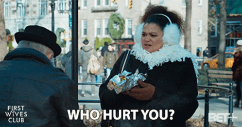 A Woman Wearing Ear Muffs Is Talking To An Older Man And Asking Who Hurt You GIF