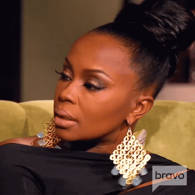 A Woman Wearing Earrings And A Black Shirt With A Bravo Logo On The Bottom GIF