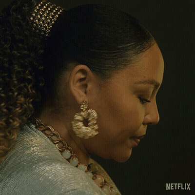 A Woman Wearing Earrings And A Necklace Says " Hey " In A Netflix Ad GIF