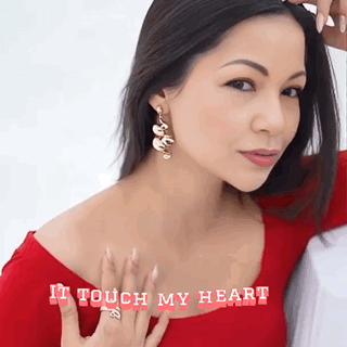 A Woman Wearing Earrings And A Ring With The Words " It Touch My Heart " On The Bottom GIF