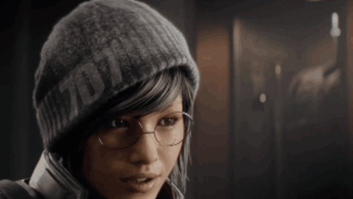 A Woman Wearing Glasses And A Beanie That Says ' 7D11 ' On It GIF