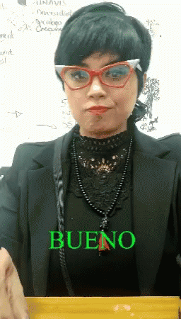 A Woman Wearing Glasses And A Black Jacket Has The Word Bueno Written On Her Shirt GIF