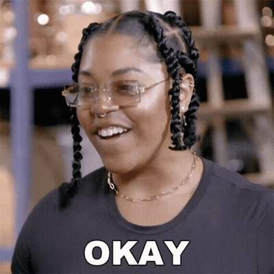 A Woman Wearing Glasses And A Black Shirt Is Smiling And Says Okay GIF