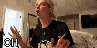A Woman Wearing Glasses And A Black Shirt With The Word Oh On The Bottom Right GIF