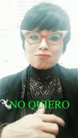 A Woman Wearing Glasses And A Black Top Says " No Quiero " GIF
