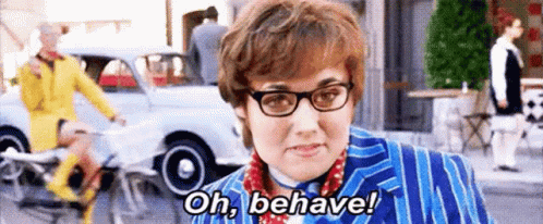 A Woman Wearing Glasses And A Blue Suit Is Saying `` Oh , Behave '' . GIF