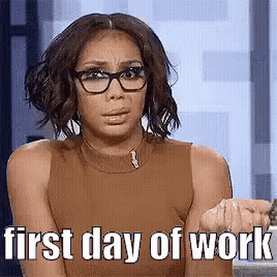A Woman Wearing Glasses And A Brown Tank Top Is Sitting In Front Of A Window . GIF
