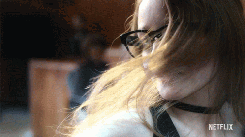 A Woman Wearing Glasses And A Choker Has A Netflix Logo In The Corner GIF