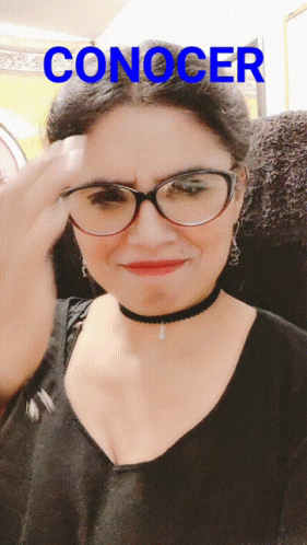 A Woman Wearing Glasses And A Choker Has The Word Conocer Written Above Her GIF