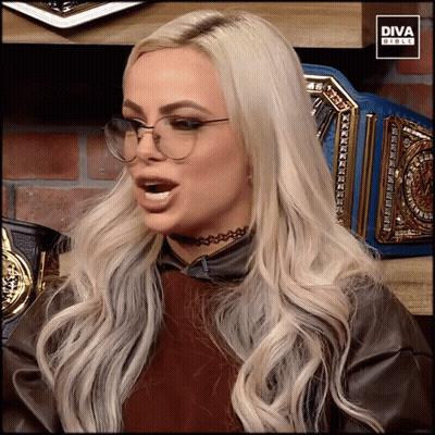 A Woman Wearing Glasses And A Choker Is Sitting In Front Of A Diva Girls Logo GIF