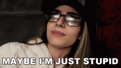 A Woman Wearing Glasses And A Hat With The Words Maybe I 'M Just Stupid Below Her GIF