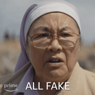 A Woman Wearing Glasses And A Head Scarf Has The Words All Fake Above Her GIF