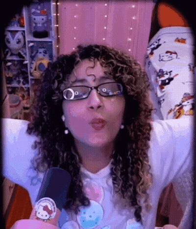A Woman Wearing Glasses And A Hello Kitty Shirt GIF