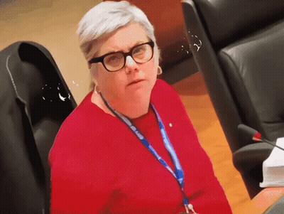 A Woman Wearing Glasses And A Lanyard That Says ' European Union ' GIF