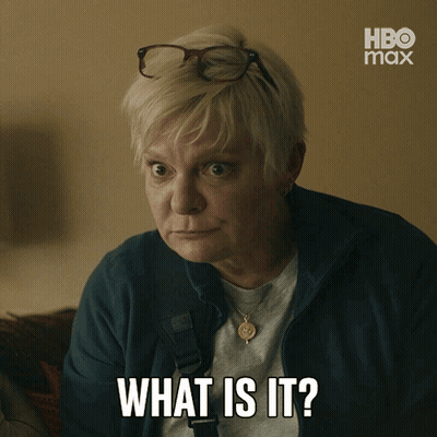 A Woman Wearing Glasses And A Necklace Says What Is It GIF