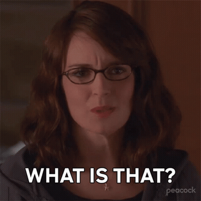 A Woman Wearing Glasses And A Necklace Says What Is That GIF