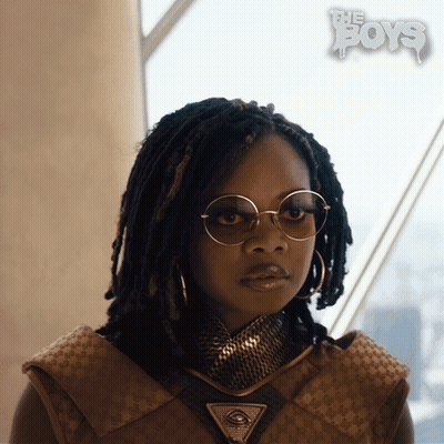 A Woman Wearing Glasses And A Necklace With The Boys Written On The Bottom Right GIF