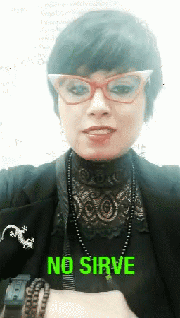 A Woman Wearing Glasses And A Necklace With The Word No Sirve On It GIF