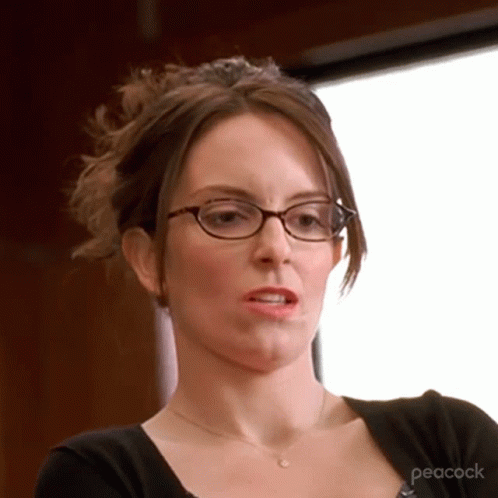 A Woman Wearing Glasses And A Peacock Shirt GIF
