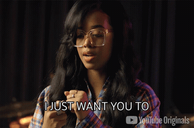 a woman wearing glasses and a plaid shirt says be closer to me