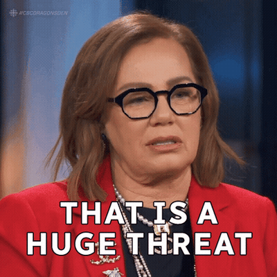 A Woman Wearing Glasses And A Red Jacket Says " That Is A Huge Threat " GIF