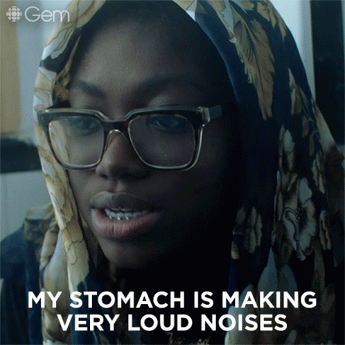 A Woman Wearing Glasses And A Scarf Has The Words My Stomach Is Making Very Loud Noises Below Her GIF