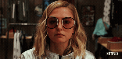A Woman Wearing Glasses And A Silver Jacket With Netflix Written On The Bottom Right GIF