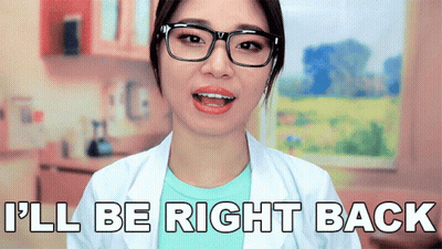 A Woman Wearing Glasses And A White Lab Coat Says I 'Ll Be Right Back GIF