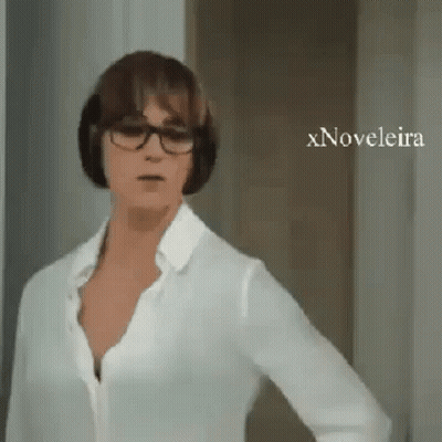 A Woman Wearing Glasses And A White Shirt Is Standing In Front Of A Door With Xnovelaira Written On The Bottom GIF