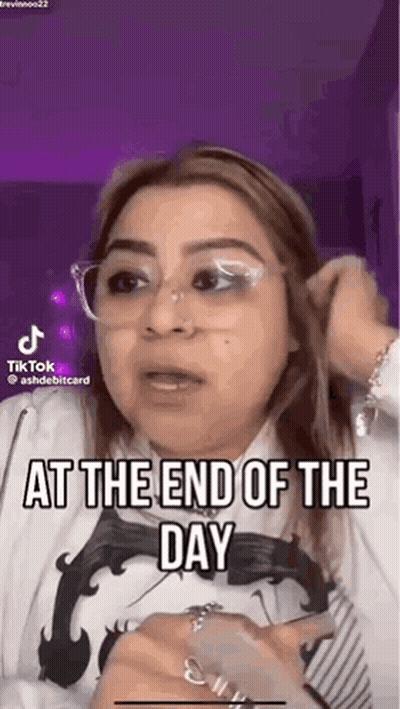 A Woman Wearing Glasses And A White Shirt Is Talking On A Tiktok Video . GIF