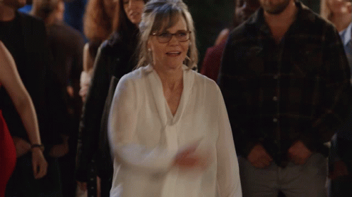 Woman With Glasses Walking Through Crowd GIF