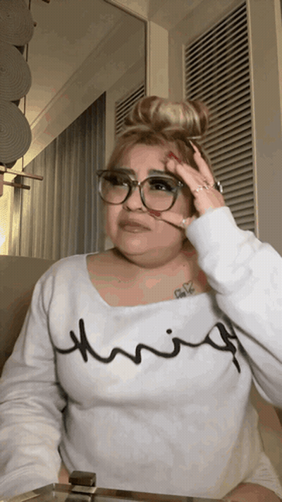 A Woman Wearing Glasses And A White Shirt That Says Thrifty On It GIF