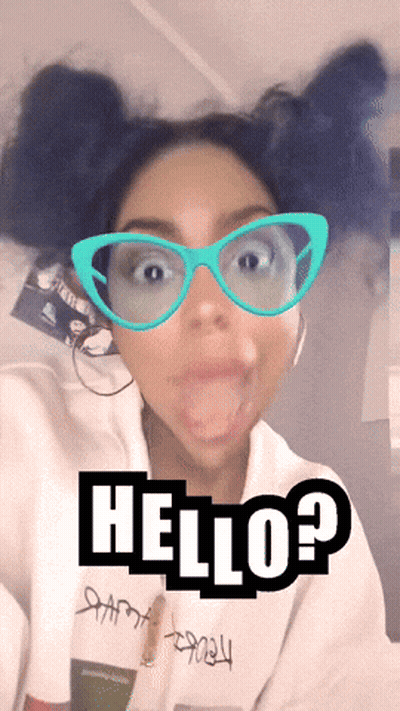 A Woman Wearing Glasses And A White Sweatshirt With The Word Hello On It GIF