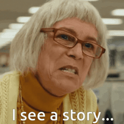 A Woman Wearing Glasses And A Yellow Sweater Has The Words " I See A Story " On Her Face GIF