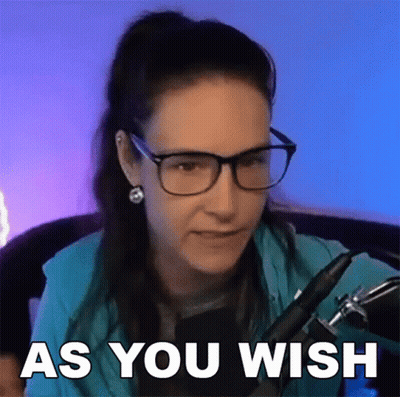 A Woman Wearing Glasses And Earrings Is Sitting In Front Of A Microphone With The Words As You Wish Above Her . GIF