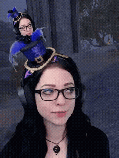 A Woman Wearing Glasses And Headphones Has A Blue Hat On Her Head GIF