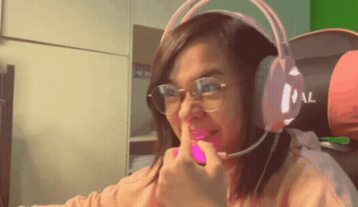 A Woman Wearing Glasses And Headphones Is Making A Face GIF