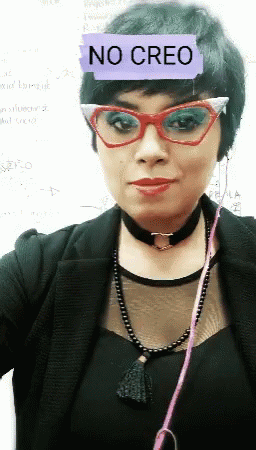 A Woman Wearing Glasses Has A No Creo Sticker On Her Head GIF