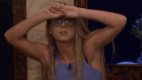 A Woman Wearing Glasses Is Covering Her Face With Her Hands And Making A Funny Face . GIF
