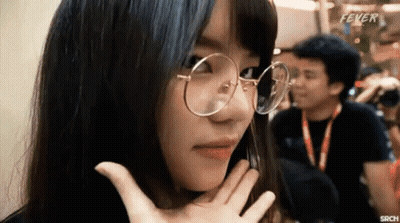A Woman Wearing Glasses Is Making A Funny Face While A Man Takes A Picture Of Her . GIF