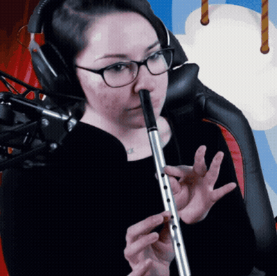 A Woman Wearing Glasses Is Playing A Flute GIF