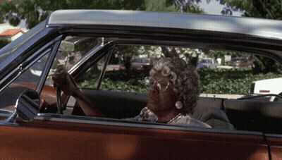 A Woman Wearing Glasses Is Sitting In A Car GIF
