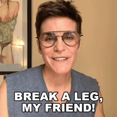 A Woman Wearing Glasses Is Smiling And Saying Break A Leg My Friend GIF