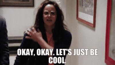 A Woman Wearing Glasses Is Standing In A Hallway And Says Okay Okay Let 'S Just Be Cool . GIF