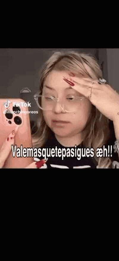A Woman Wearing Glasses Is Taking A Selfie With Her Phone And Making A Funny Face . GIF